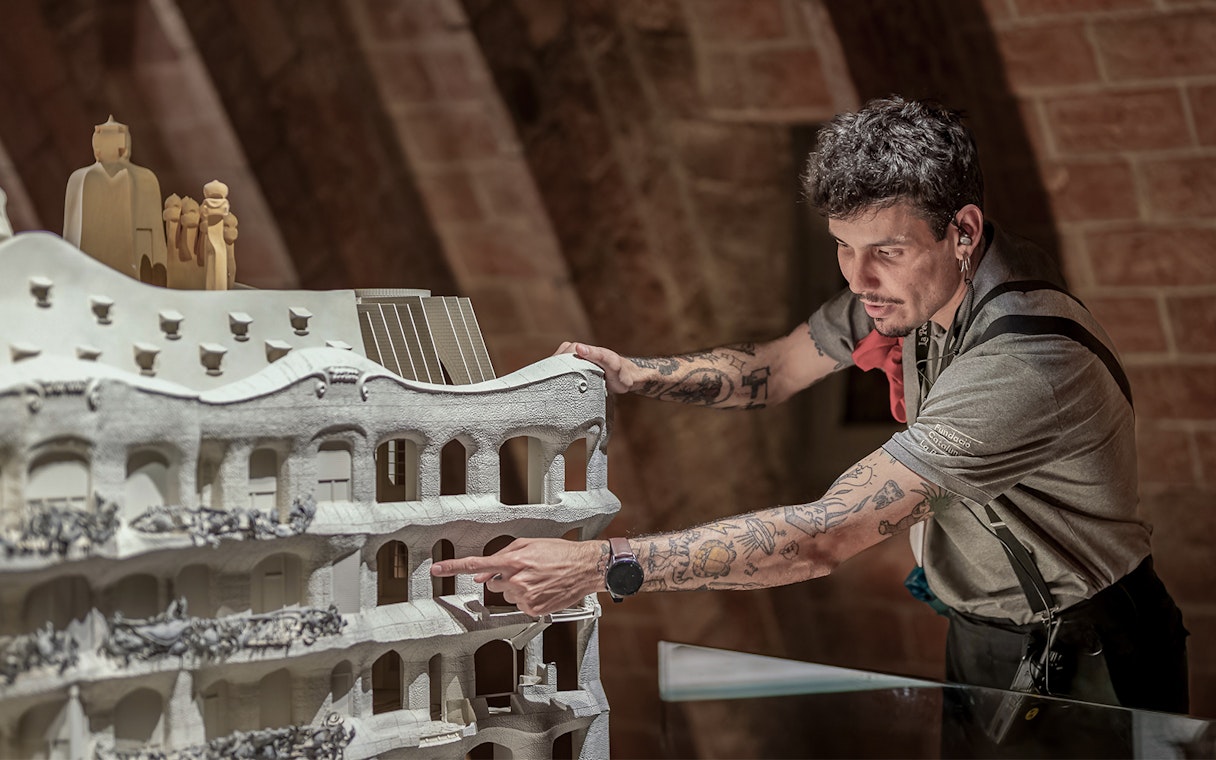Guide explaining Casa Mila model during La Pedrera Night Experience in Barcelona.