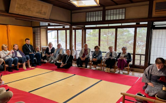 Guests seated in a traditional tea room in Kyoto during a tea ceremony.