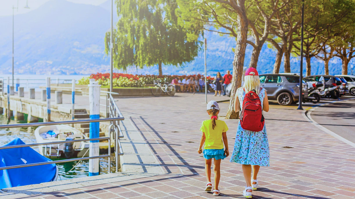 Mother and daughter walking on a scenic promenade in Cinque Terre, Italy.