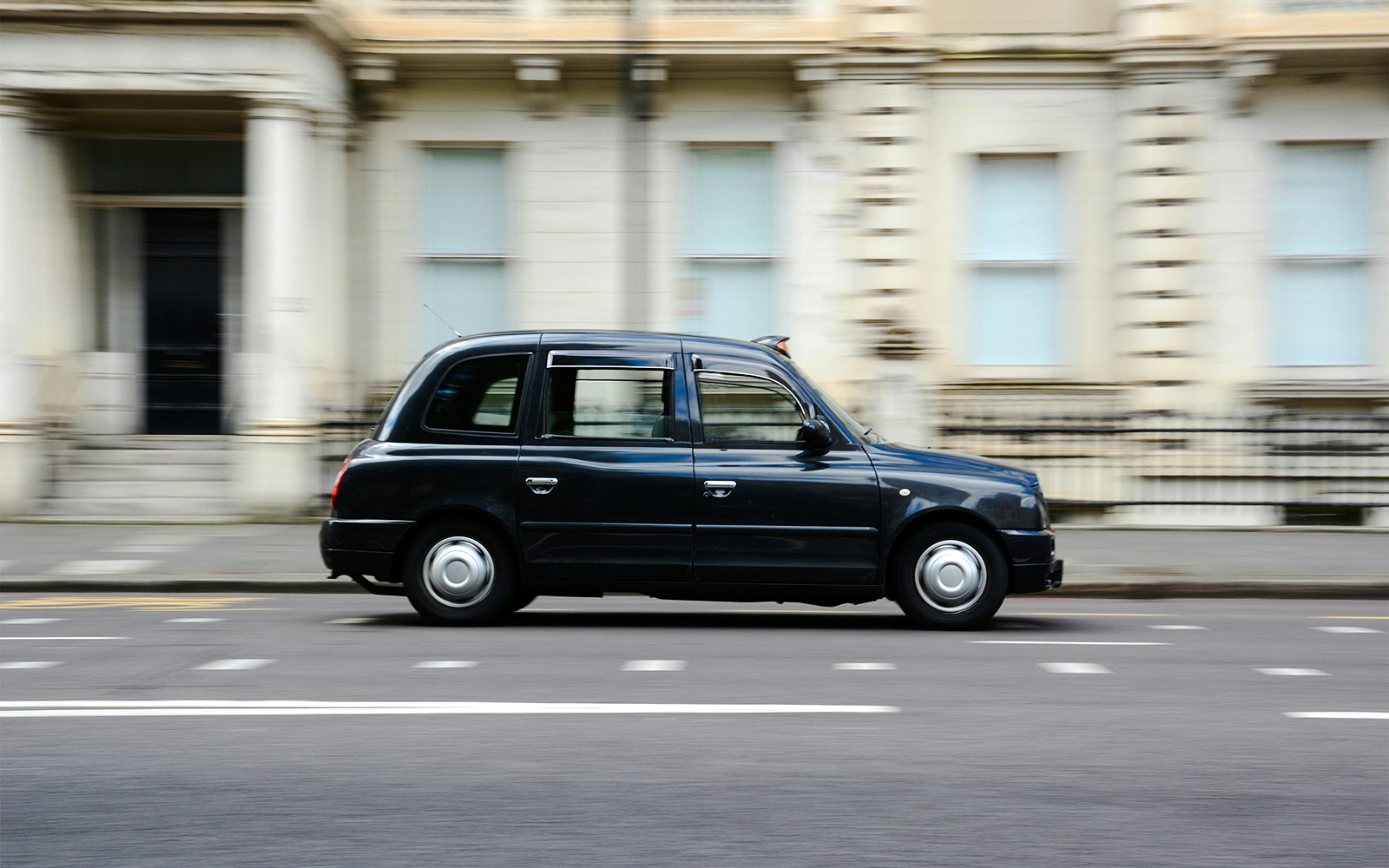 London black cab driving on a city street.