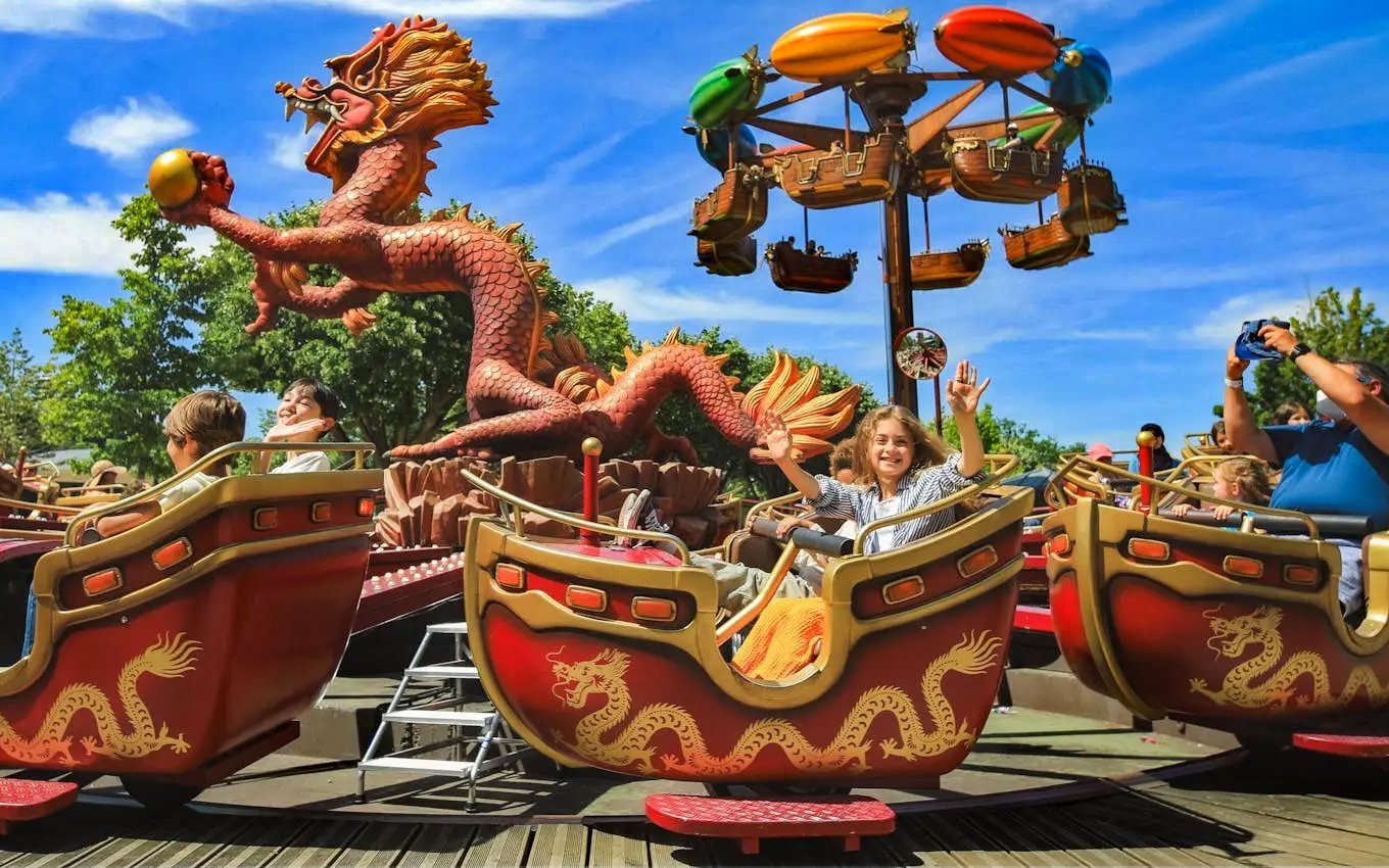 Visitors enjoying a dragon-themed ride at Jardin d'Acclimatation, Paris.