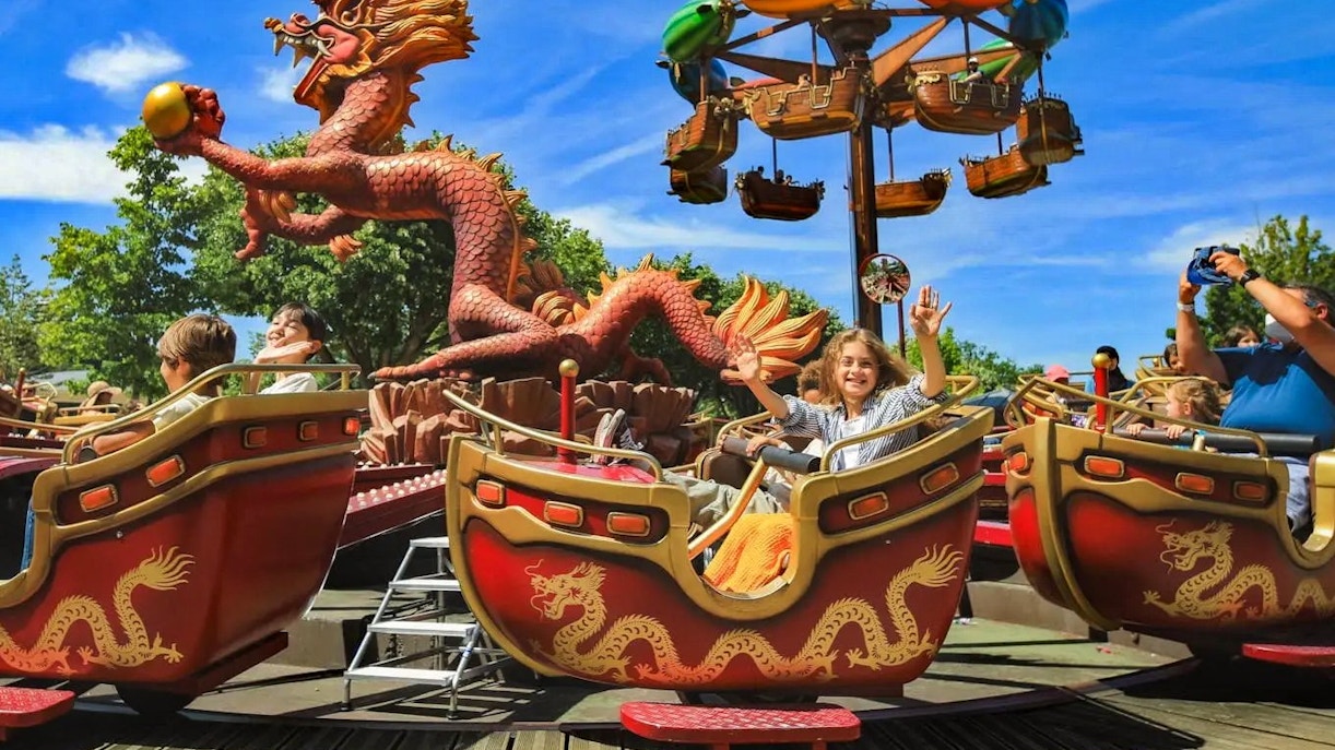 Visitors enjoying a dragon-themed ride at Jardin d'Acclimatation, Paris.