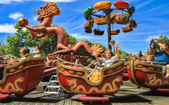 Visitors enjoying a dragon-themed ride at Jardin d'Acclimatation, Paris.