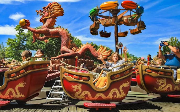 Visitors enjoying a dragon-themed ride at Jardin d'Acclimatation, Paris.