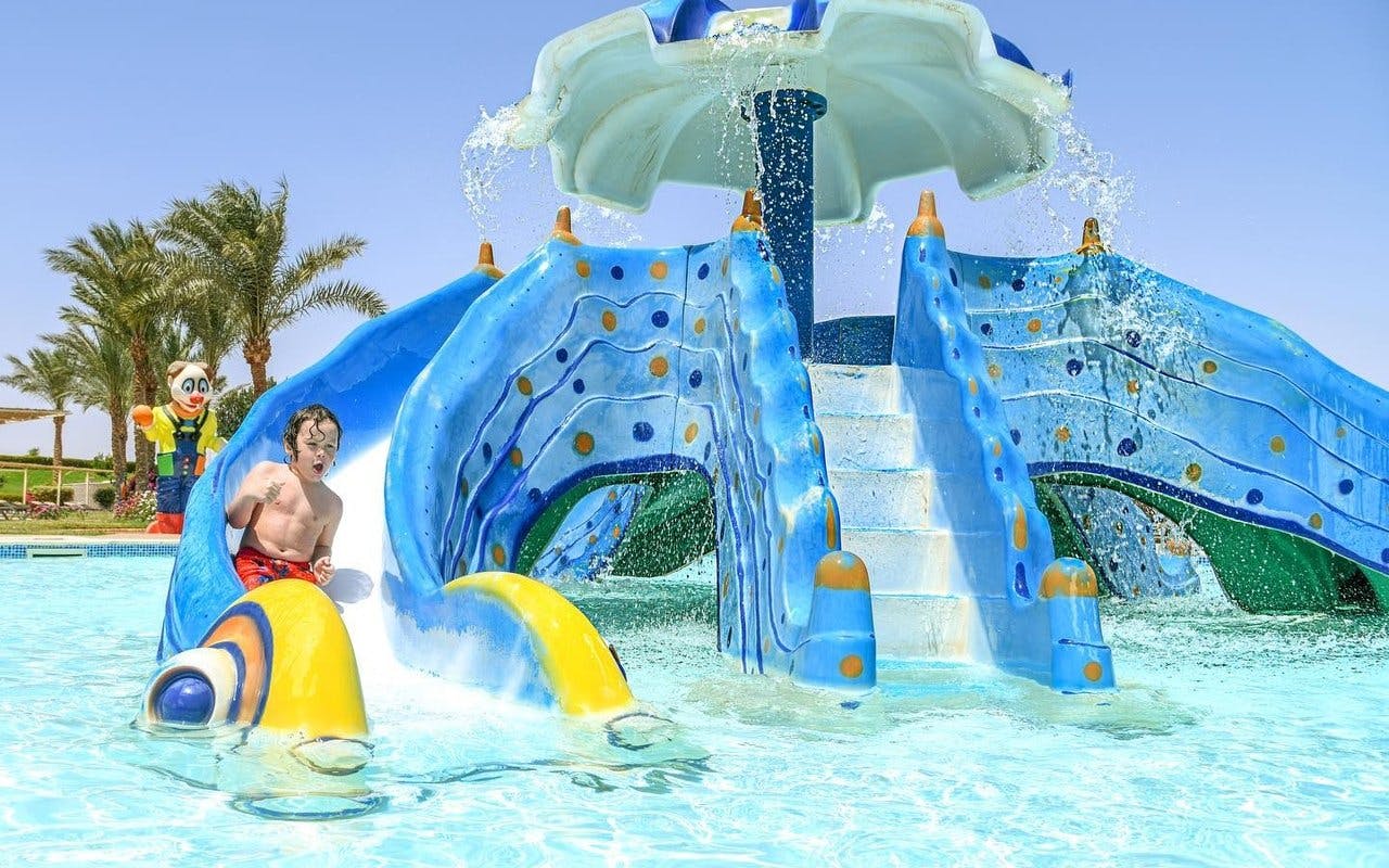 Child sliding down a colorful water slide at Makadi Water World, Hurghada.