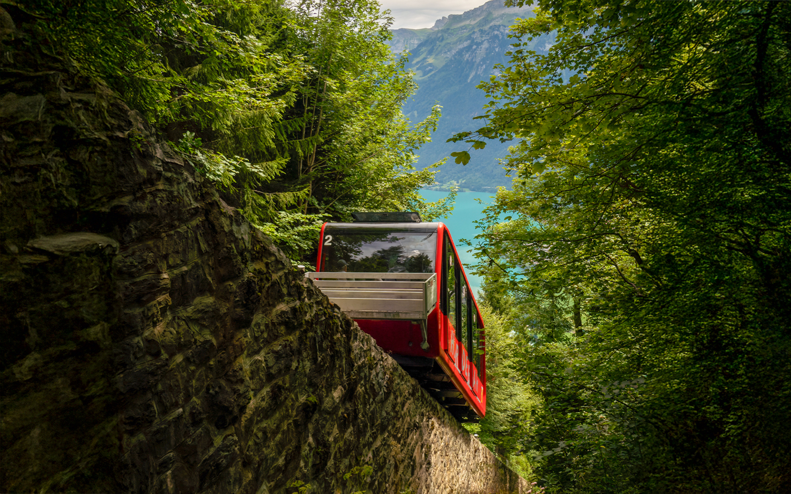 Harder Kulm funicular ascending through lush Swiss Alps with panoramic views of Interlaken.