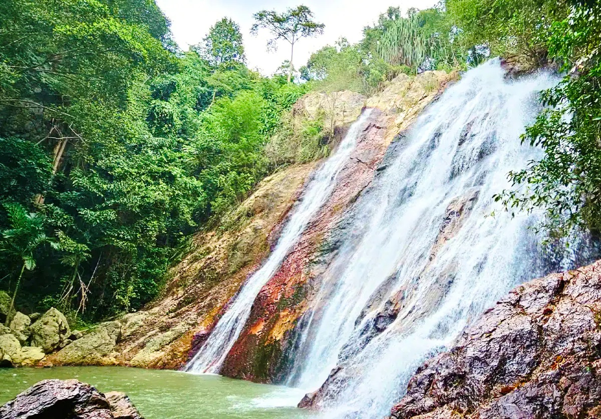 Waterfall surrounded by lush greenery on Koh Samui island, part of cultural and scenic tour.