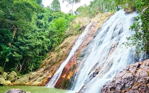 Waterfall surrounded by lush greenery on Koh Samui island, part of cultural and scenic tour.