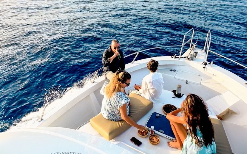 Tourists enjoying snacks and drinks on a boat during a sunset cruise in Gran Canaria.