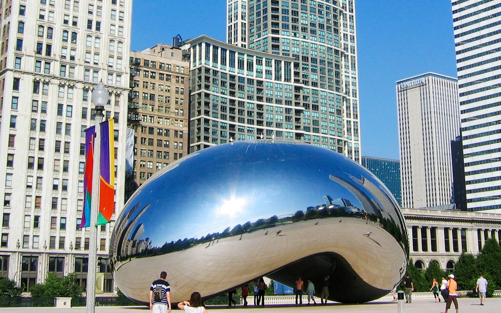 Cloud Gate sculpture in Millennium Park, Chicago, with city skyline in the background.