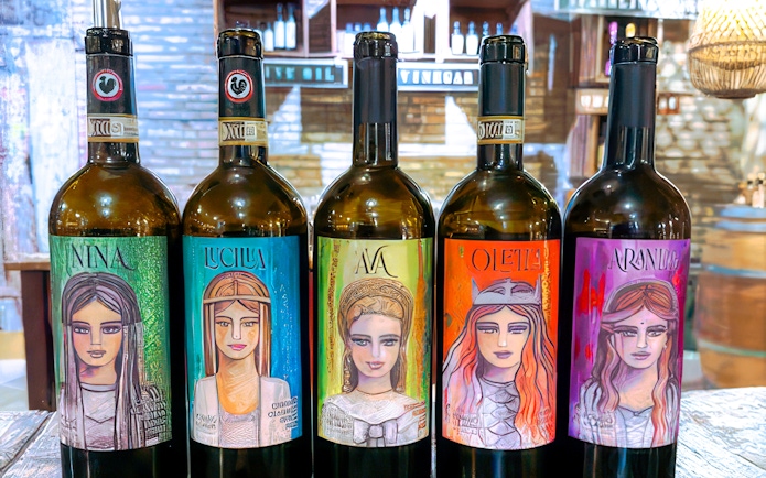 Chianti wine bottles with artistic labels displayed during Italy day trip.