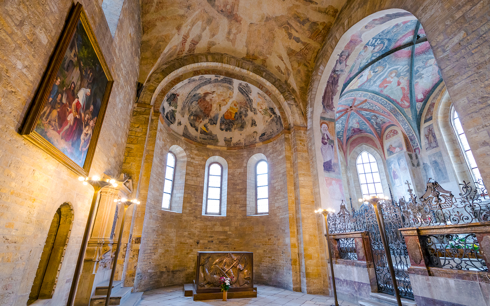 Basilica of St George interior with frescoed ceilings and arched windows.