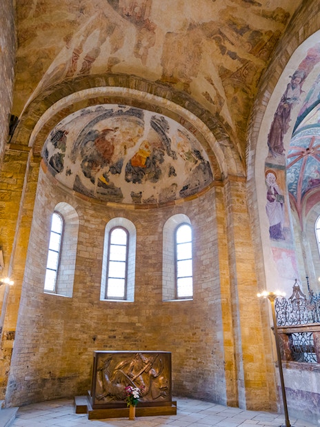 Basilica of St George interior with frescoed ceilings and arched windows.