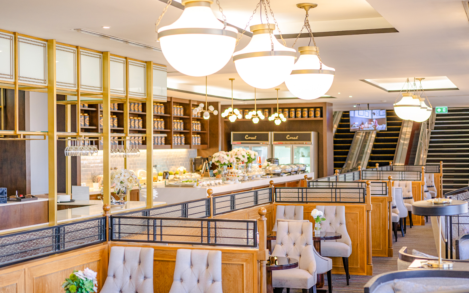Dining area at The Coral Executive Lounge, Bangkok Airport, featuring elegant seating and buffet setup.
