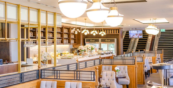 Dining area at The Coral Executive Lounge, Bangkok Airport, featuring elegant seating and buffet setup.