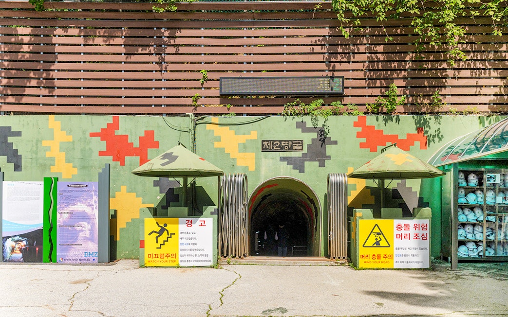 Entrance to the DMZ 2nd Tunnel with safety signs and helmets on display.