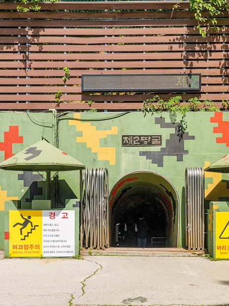 Entrance to the DMZ 2nd Tunnel with safety signs and helmets on display.
