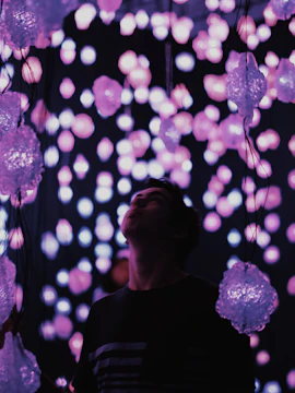 Visitor exploring glowing light installation at Dark Mansion Museum.