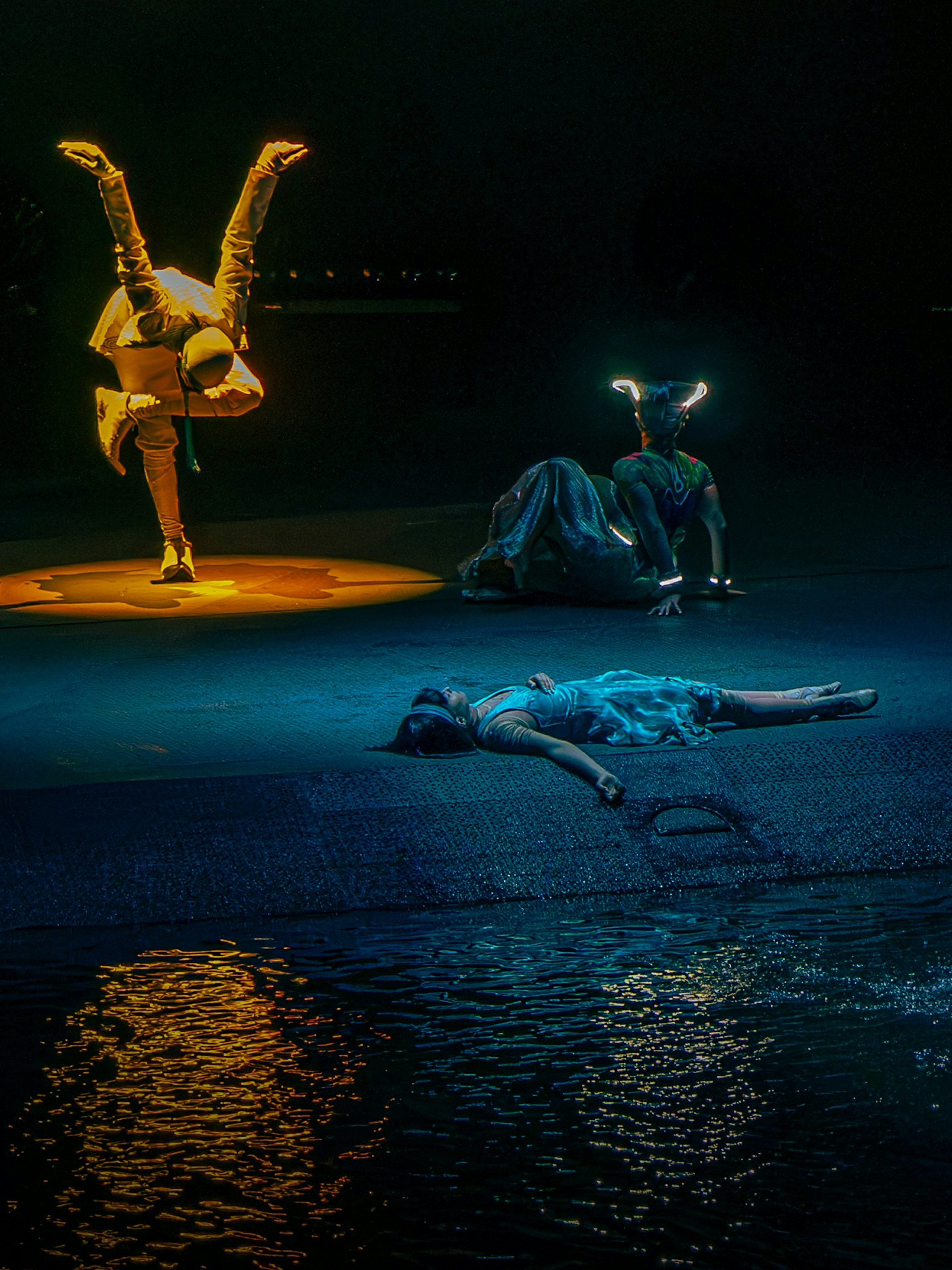 Acrobats performing at La Perle show in Dubai with water reflections.