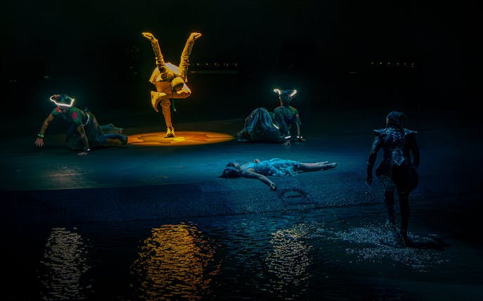 Acrobats performing at La Perle show in Dubai with water reflections.