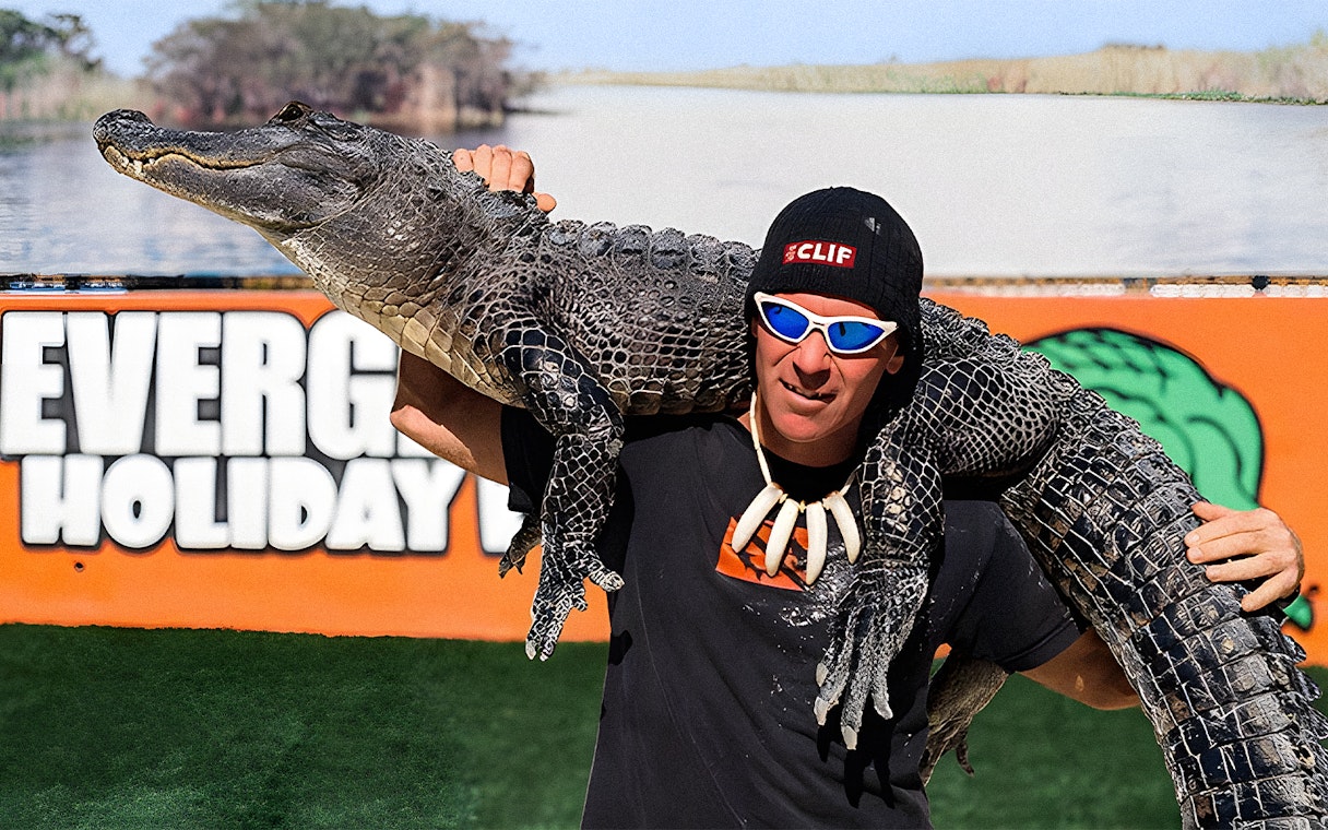 Man holding an alligator at Holiday Park during airboat tour and wildlife show.