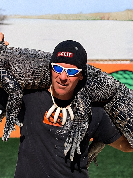 Man holding an alligator at Holiday Park during airboat tour and wildlife show.