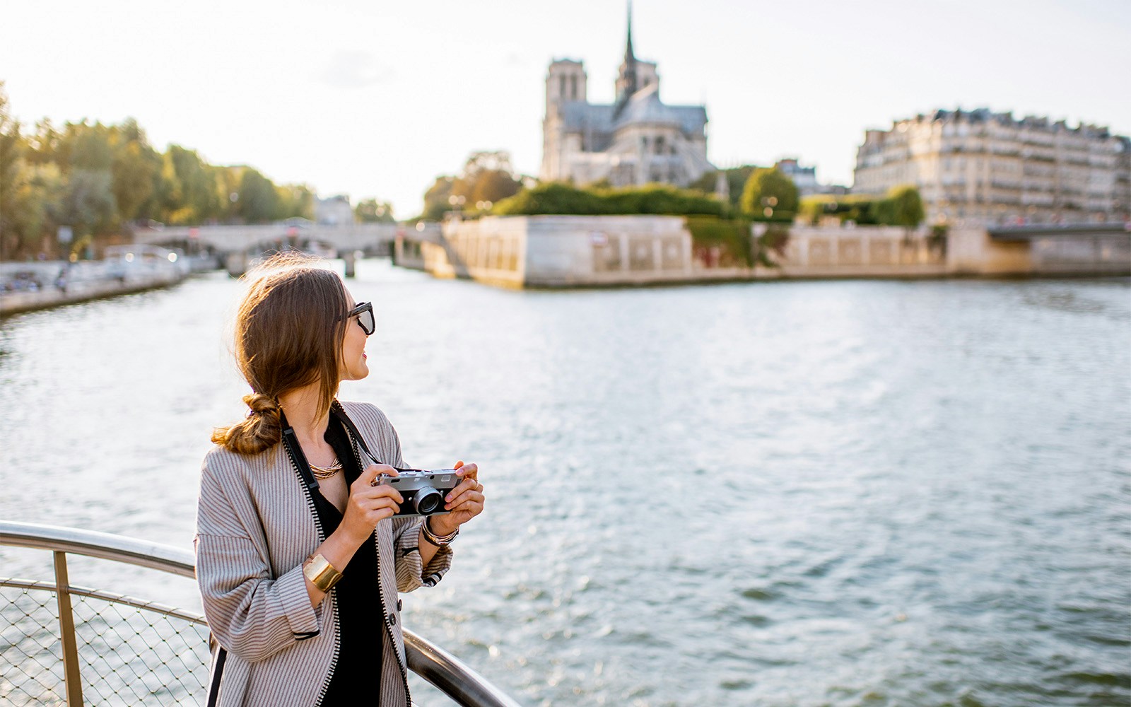 Seine River cruise boat passing by the Eiffel Tower in Paris, France.