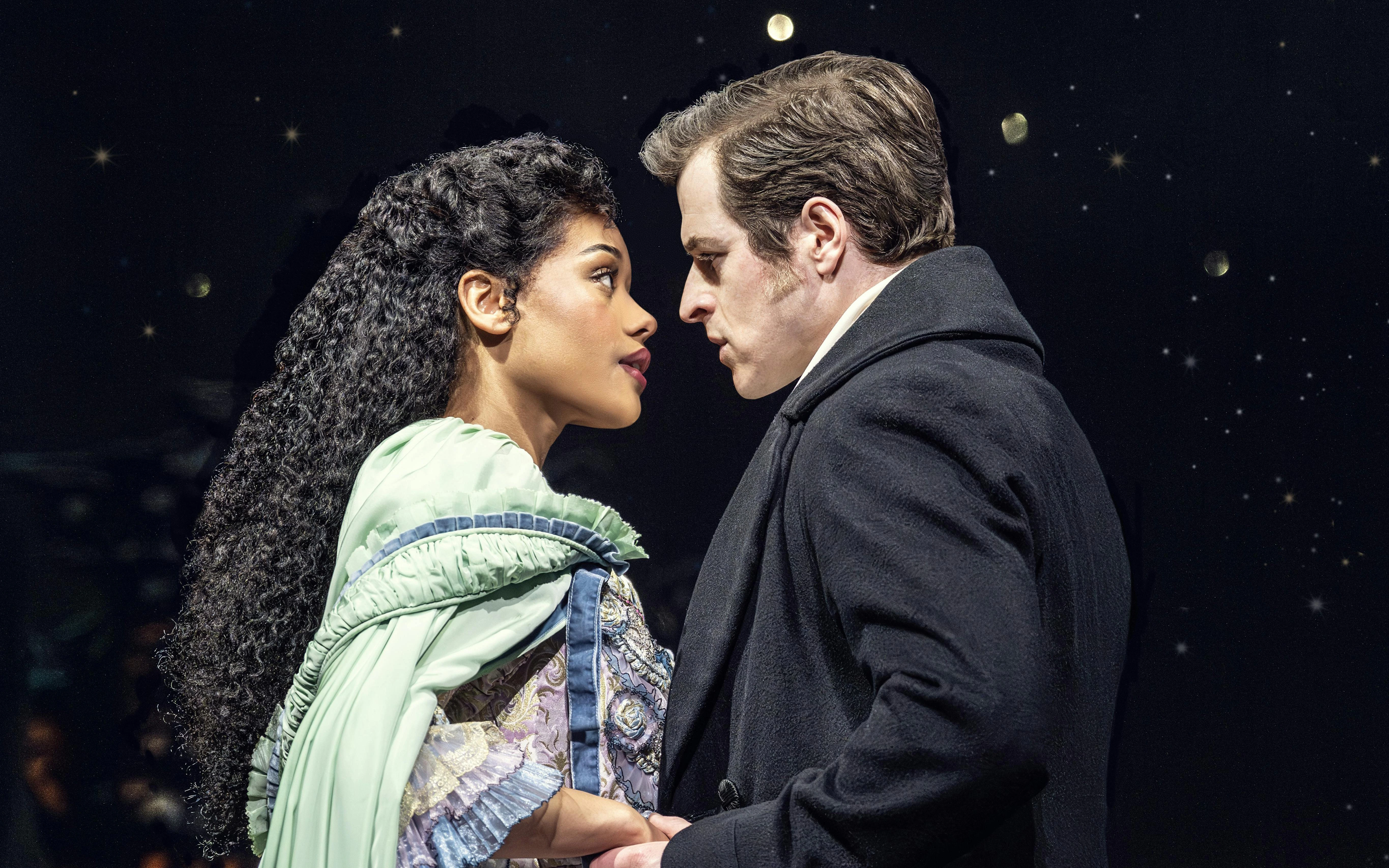 Actors in a dramatic scene from Phantom production, under a starry night backdrop.