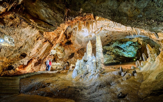 Tourists exploring stalagmites and stalactites inside Lipa Cave, Cetinje.