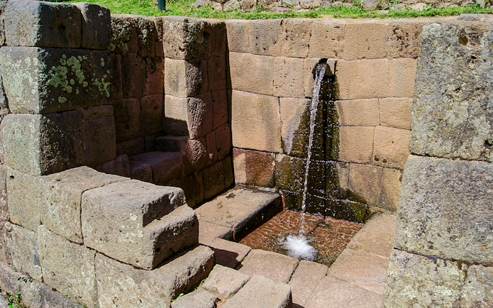 Ceremonial stone fountain with flowing water at Machu Picchu, Peru.