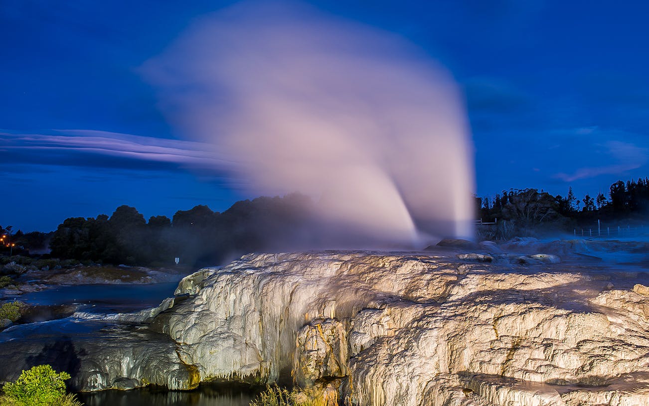 Te Puia geysers erupting at night during a private guided tour in New Zealand.