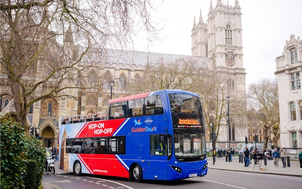 Golden Tours hop-on hop-off bus near Westminster Abbey, London.