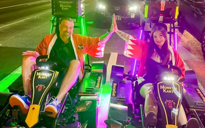 Couple high-fiving on electric go-karts during Asakusa tour at night.