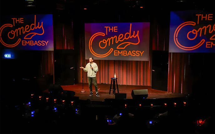 Comedian performing on stage at The Comedy Embassy.
