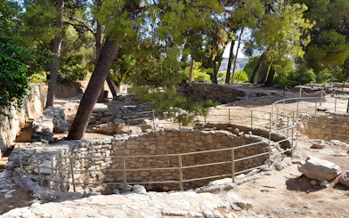 Ancient stone structures and trees in the yard of Knossos Palace, Crete.