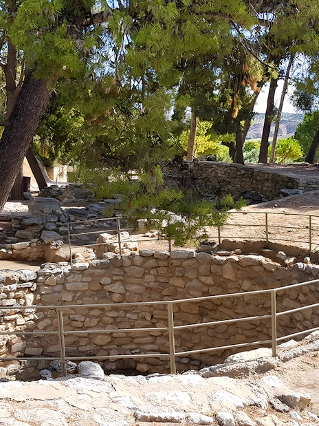 Ancient stone structures and trees in the yard of Knossos Palace, Crete.