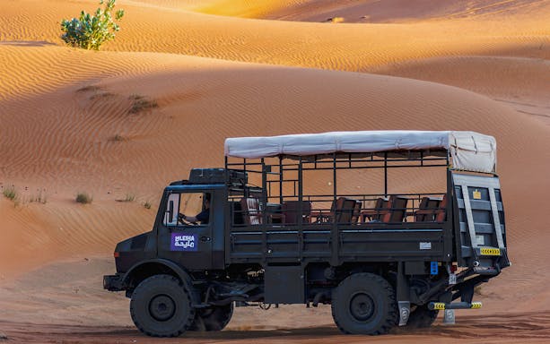 UniMog vehicle on a guided tour at Mleiha Archeological Centre, UAE desert landscape.