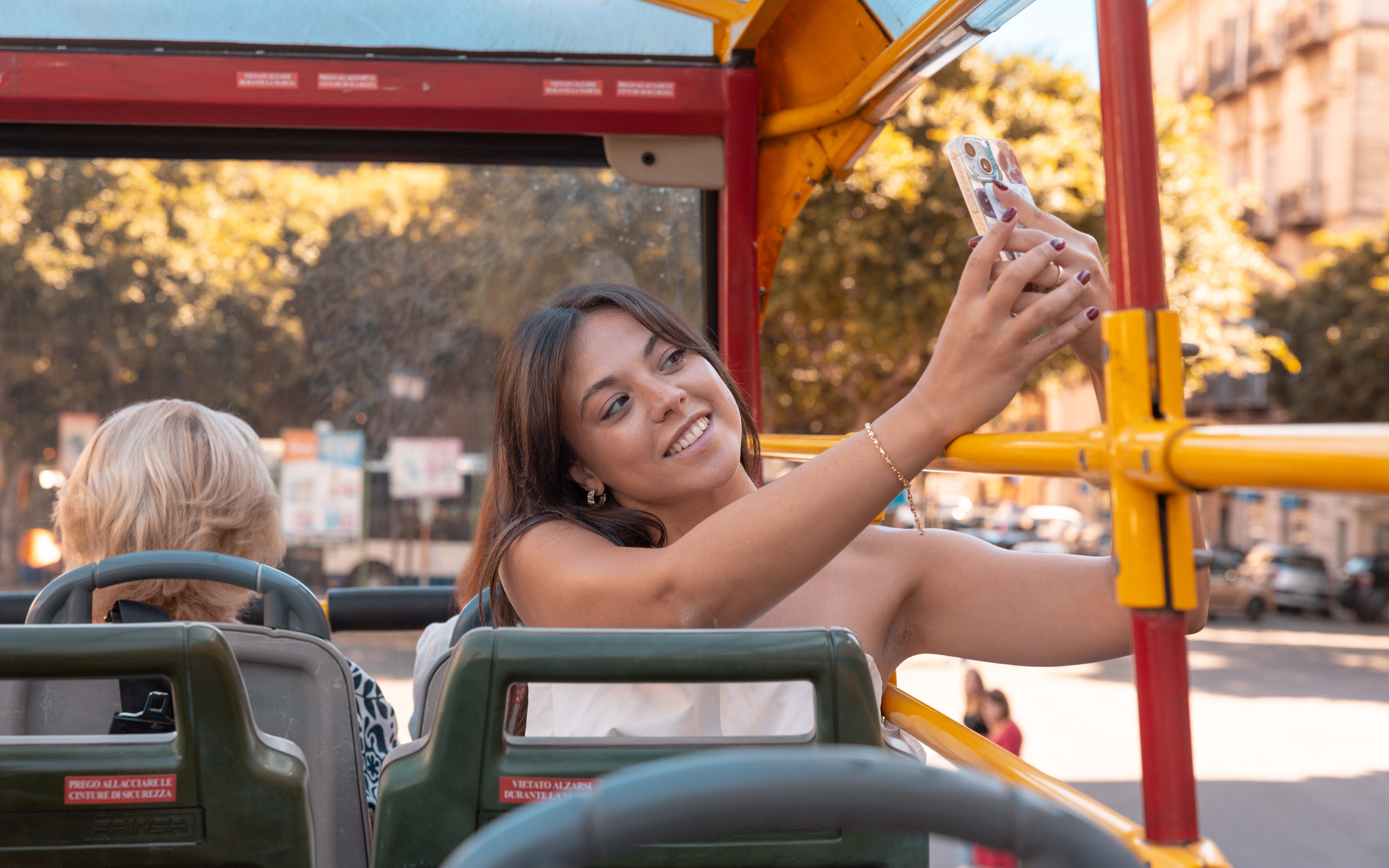People taking selfies on the City Sightseeing bus in Palermo.