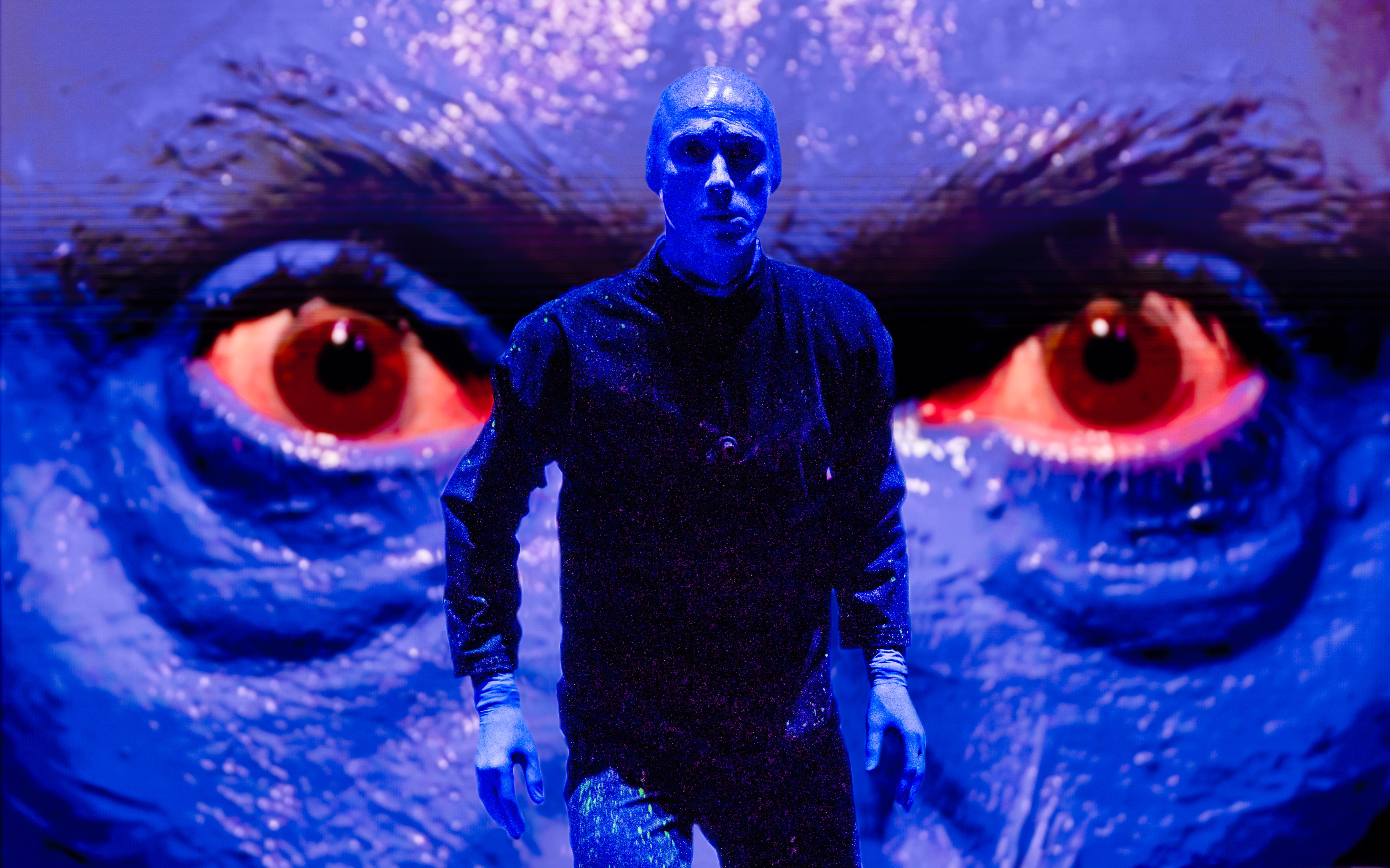 Blue Man Group performer on stage with large blue face backdrop, Orlando.