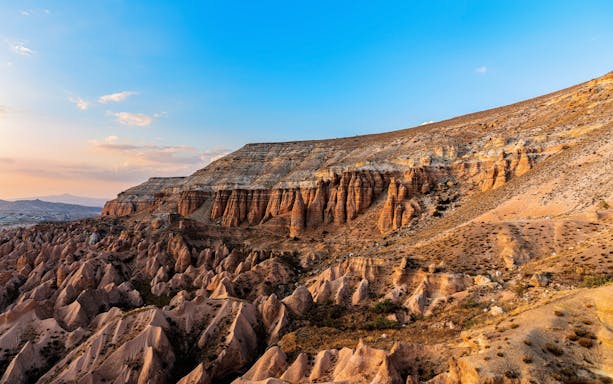 Goreme's Red Valley rock formations in Cappadocia, Turkey, under a clear blue sky.