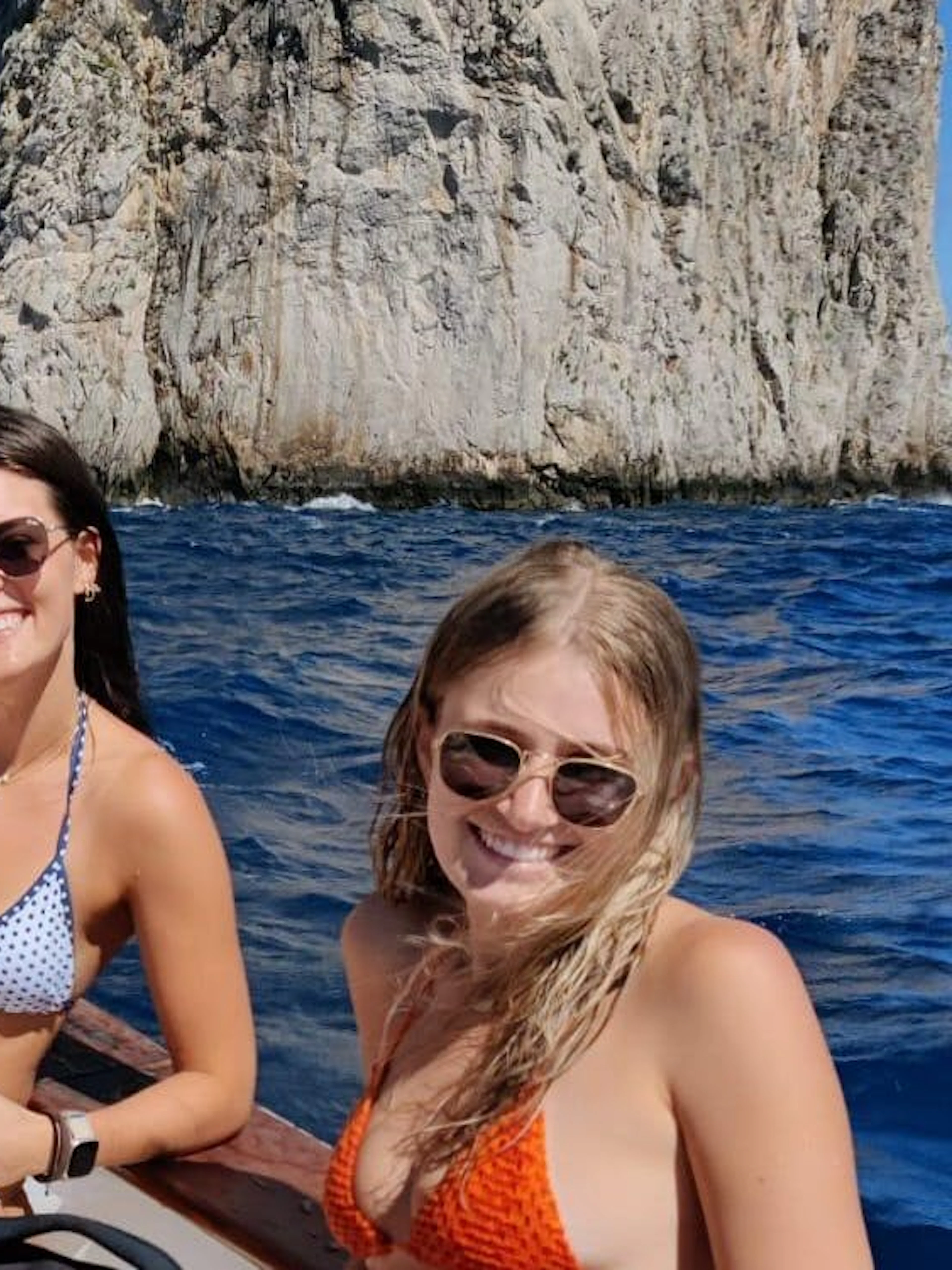Group enjoying Capri boat tour near Faraglioni rocks.