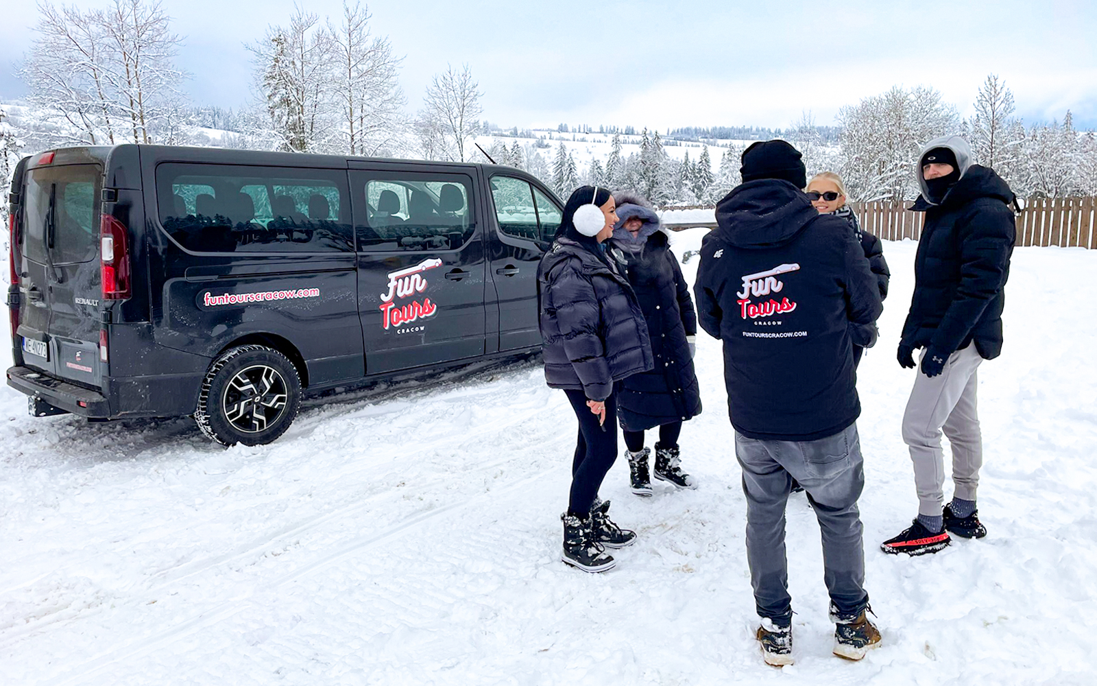 Group by a van in snowy landscape for roundtrip AC private transfers.