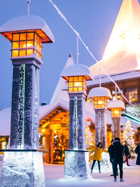 Central plaza of Santa’s Village with illuminated Arctic Circle markers and festive decorations.
