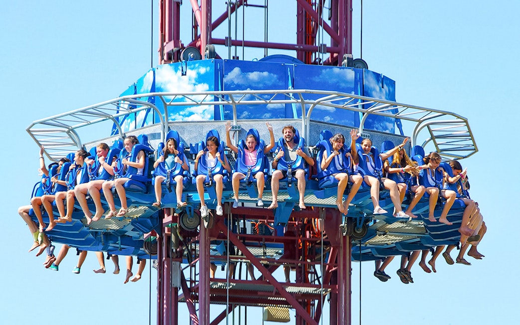 Tourists on El Desafío ride at Isla Mágica, Seville, experiencing a thrilling drop.