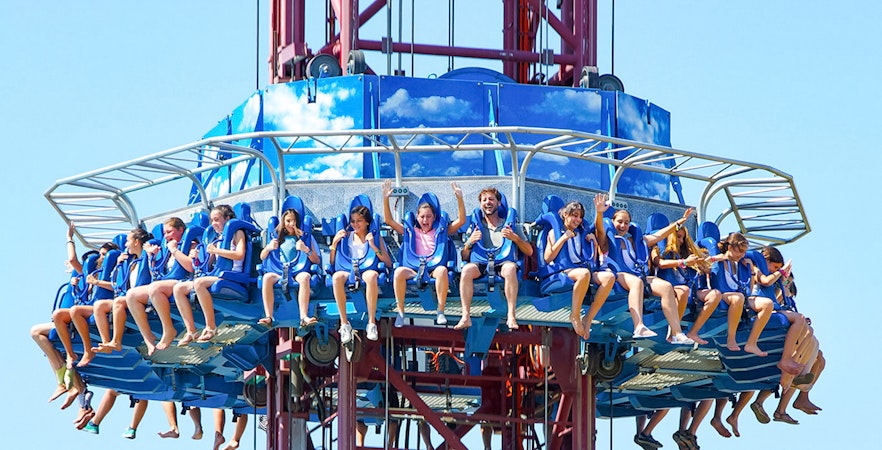 Tourists on El Desafío ride at Isla Mágica, Seville, experiencing a thrilling drop.