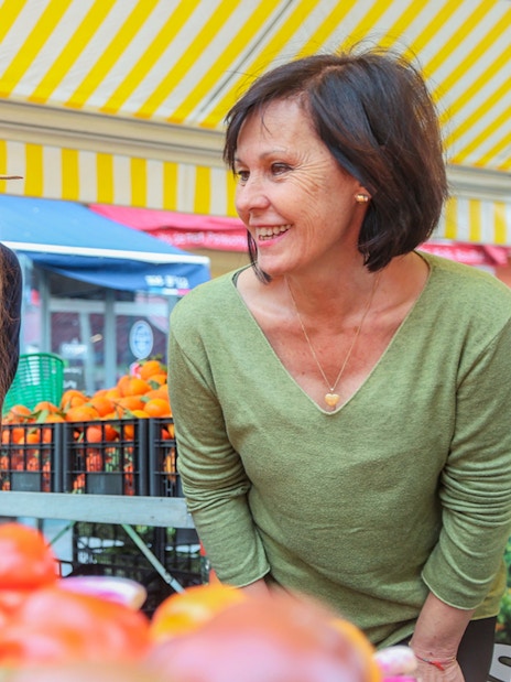 Women exploring a vibrant market in Nice during a walking and driving tour.