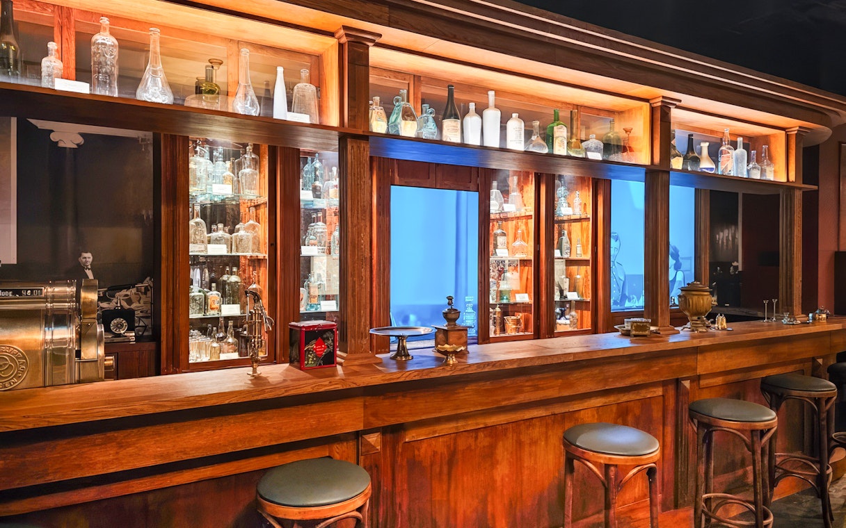 Vodka bottles displayed on wooden shelves at a museum bar, Krakow.