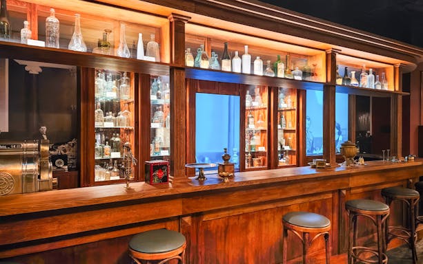 Vodka bottles displayed on wooden shelves at a museum bar, Krakow.