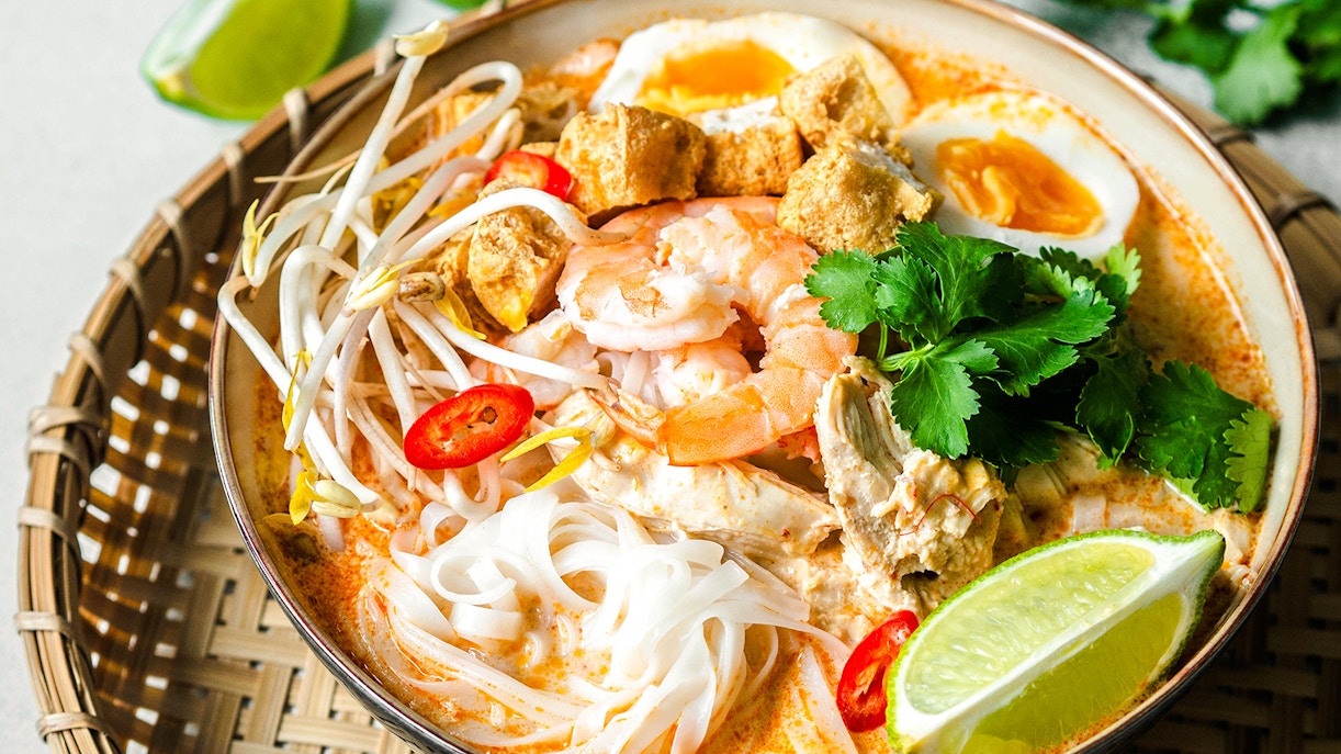 Singaporean seafood laksa with prawns, noodles, and lime.