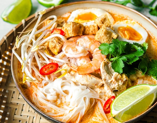 seafood laksa with prawns, noodles, and lime.